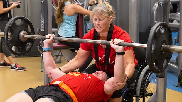 Retired corporal Christine Gauthier spots for retired master corporal Natacha Dupuis on the bench press while training for the Invictus Games.